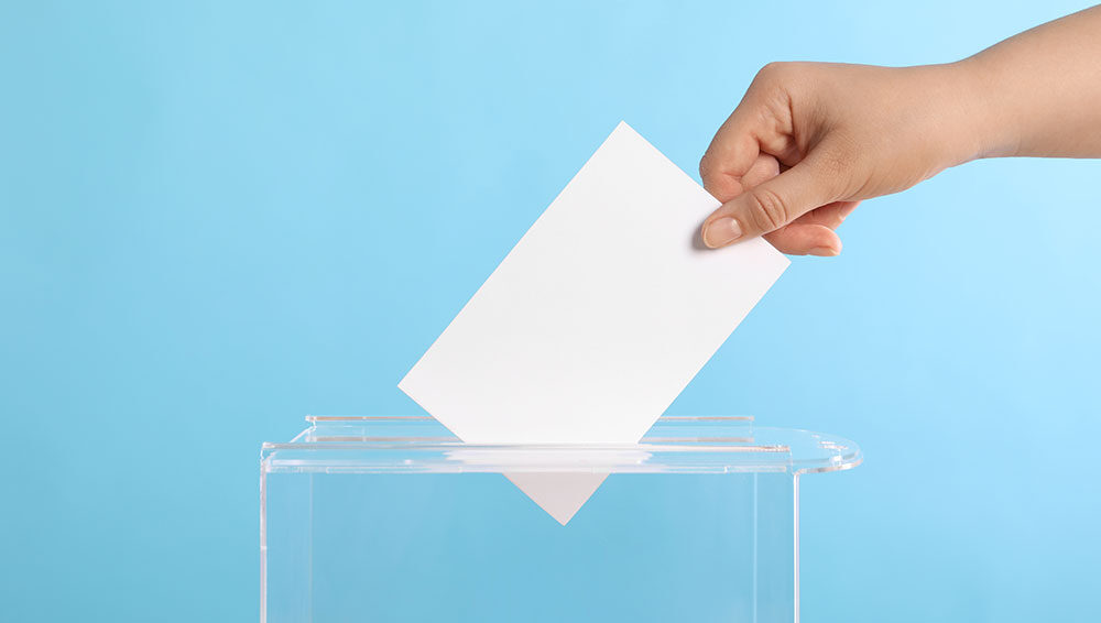 ballot being put into clear voting box